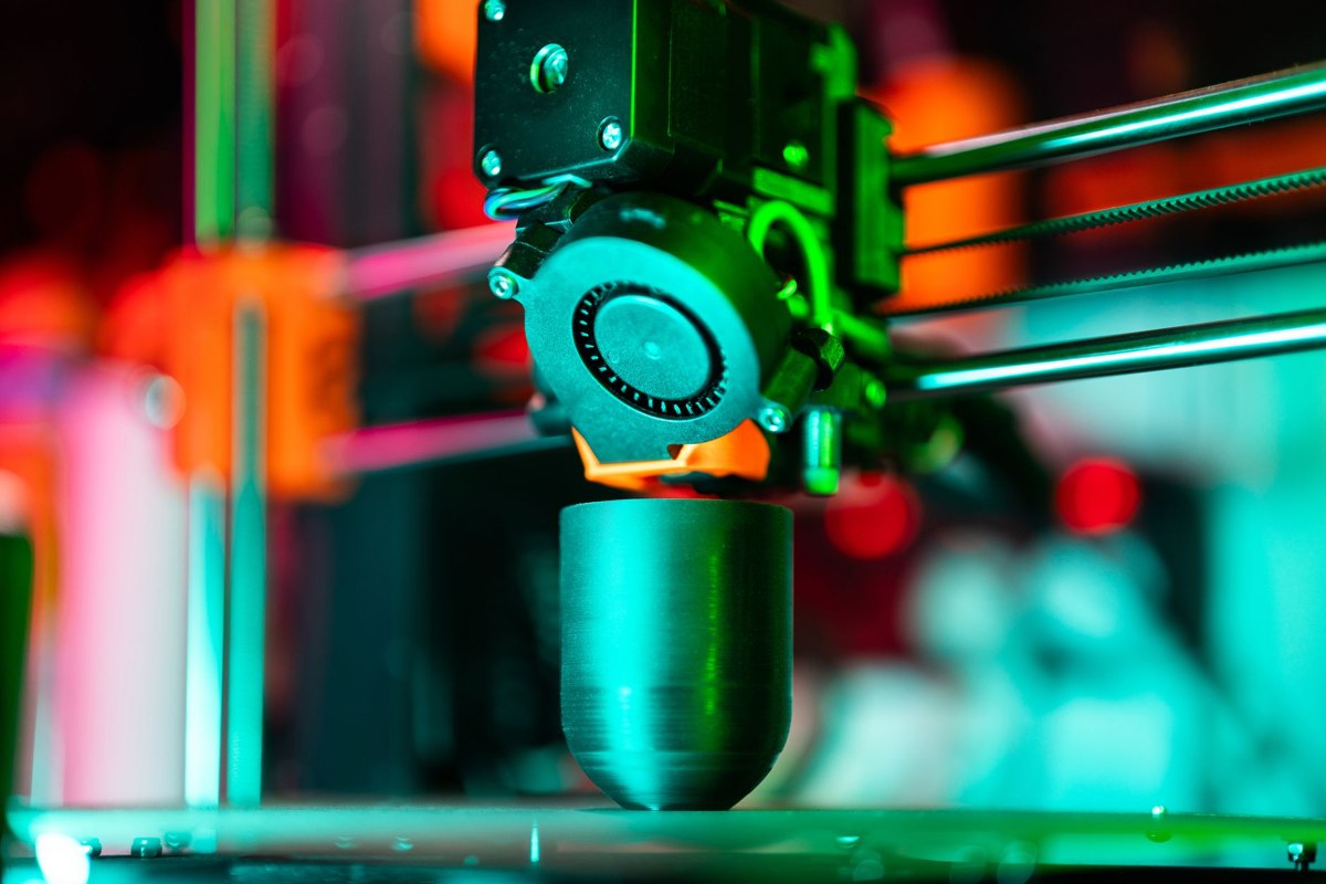 Impressora 3D em funcionamento durante o processo de impress&atilde;o de uma pe&ccedil;a
